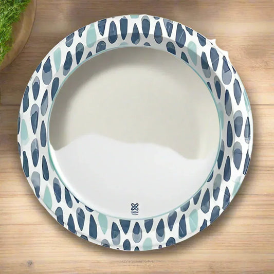 Disposable paper plate with blue and teal brushstroke pattern on wooden surface