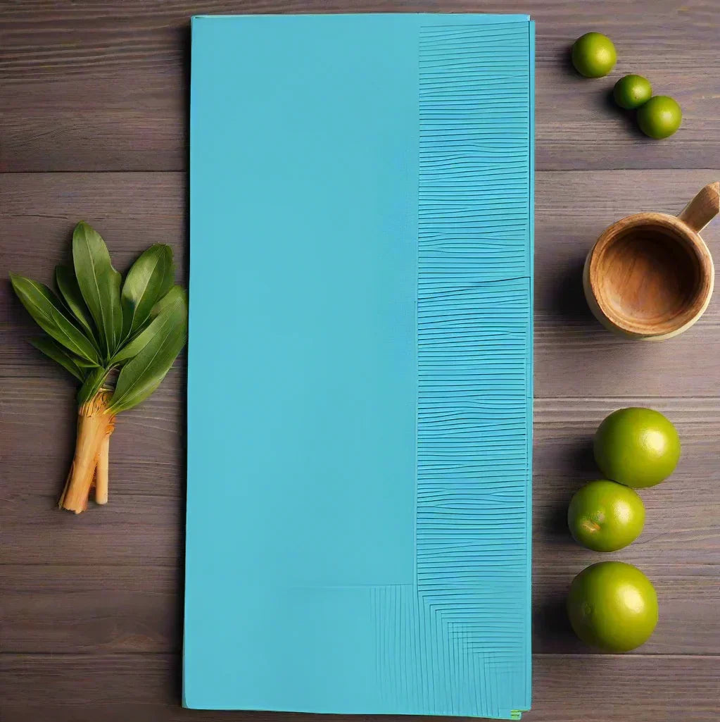 Blue disposable table mat with textured lines on wooden surface surrounded by fresh green limes and leaves