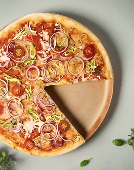 Pizza with sliced red onions, cherry tomatoes, and greens in a biodegradable wooden disposable plate