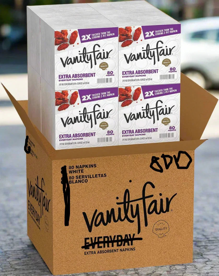 A cardboard box containing four packages of Vanity Fair Extra Absorbent Everyday Napkins. The box is labeled with the brand name and the product's details, including "80 NAPKINS WHITE." The product is from One Use Classic.