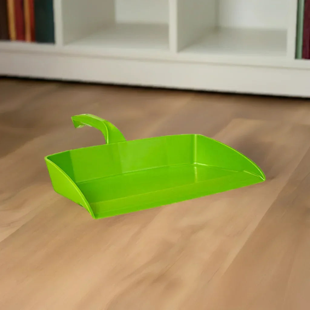Bright green plastic dustpan on wooden floor with white bookshelf background