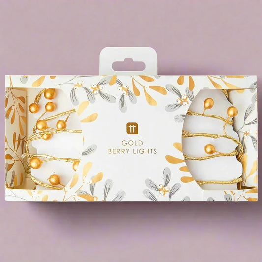 Box of gold berry string lights with decorative packaging on a purple background