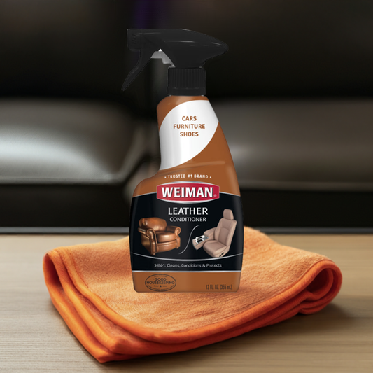 Weiman OneUse Classic Leather Conditioner spray bottle on orange cloth for cleaning, conditioning, and protecting leather furniture and car seats