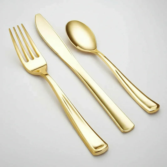Gold-colored disposable fork, knife, and spoon set on a white background for stylish tableware