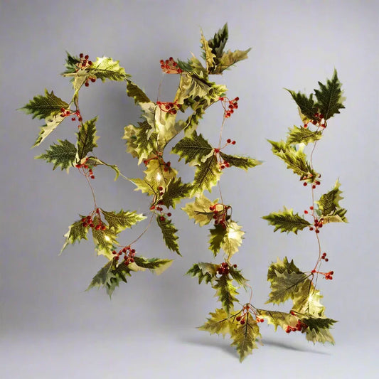 Decorative holly garland with green leaves, red berries, and small warm white LED lights