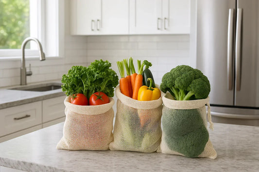 Reusable mesh produce bags with fresh vegetables on kitchen counter in modern white kitchen