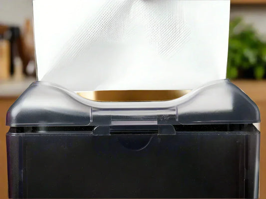 close-up of black napkin dispenser with white folded paper napkins for restaurant or food service
