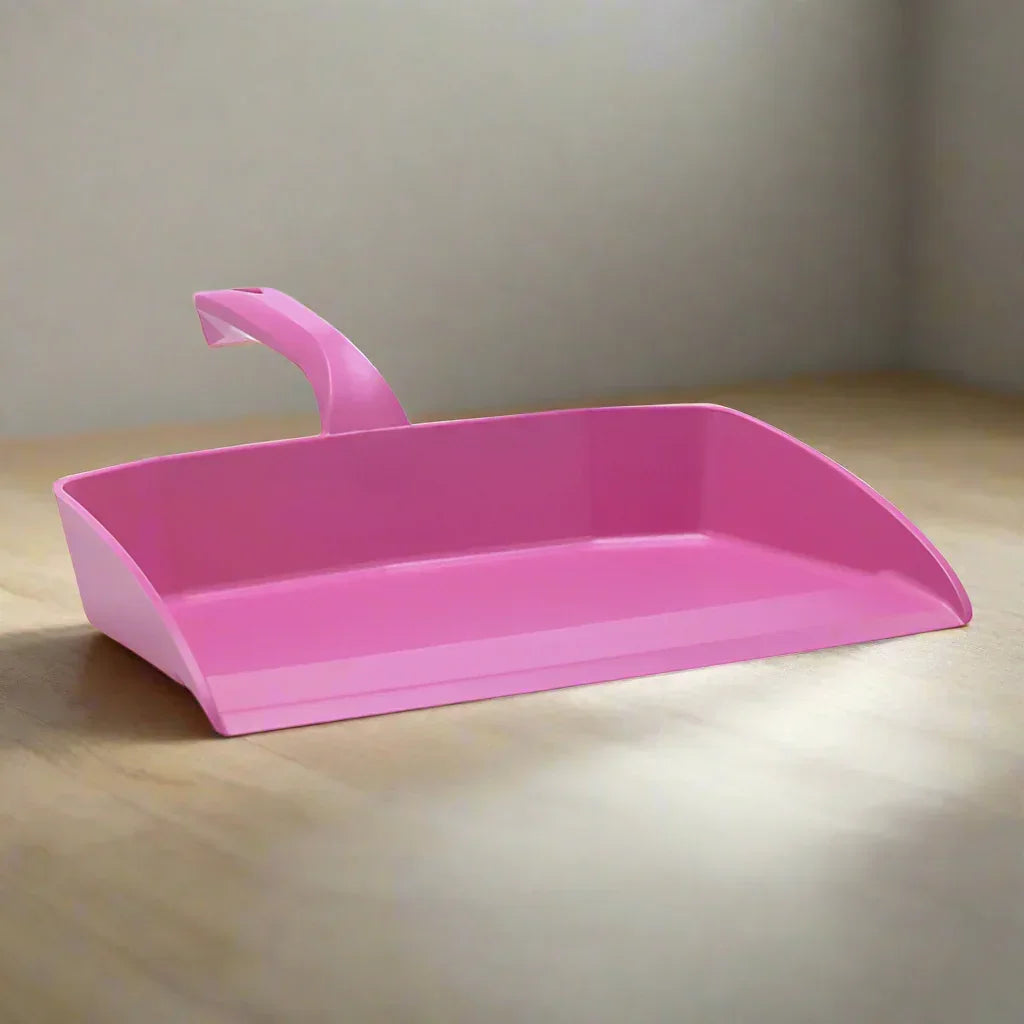 Pink plastic dustpan on a wooden surface, durable cleaning tool for professional use