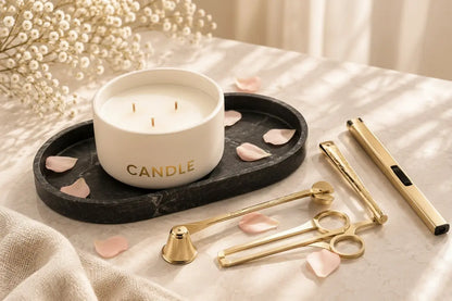 Elegant aesthetic candle decor setup with gold tools and a black marble tray bathed in warm dappled sunlight with gypsophila flowers.