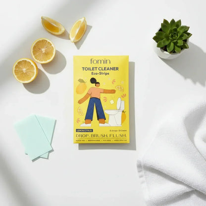 Yellow box of Fomin lemon citrus toilet cleaner eco-strips with lemon slices, green succulent, white towel