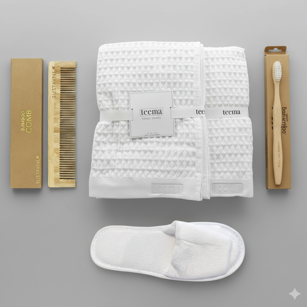 Curated luxury waffle bath towel spa gift bundle on white background, featuring a folded white organic Turkish cotton towel stack, plush velour Garnier-Thiebaut slippers, and eco-friendly bamboo essentials including a detangling comb and toothbrush.
