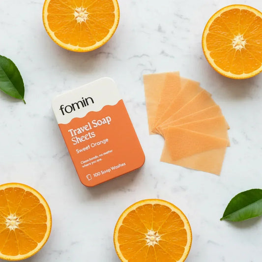 Fomin travel soap sheets with sweet orange scent displayed with orange slices and green leaves on marble surface