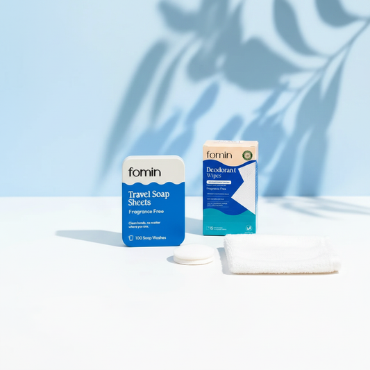 Fragrance-free travel hygiene bundle flat lay — soap sheets, deodorant wipes and compressed towels on white background