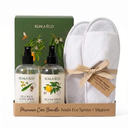 Eco-luxury home care bundle featuring Garnier-Thiebaut white velour slippers and Koala Eco natural aromatherapy sprays (Pillow & Linen spray and Room spray) on studio style. Premium wellness gift set for home experience.