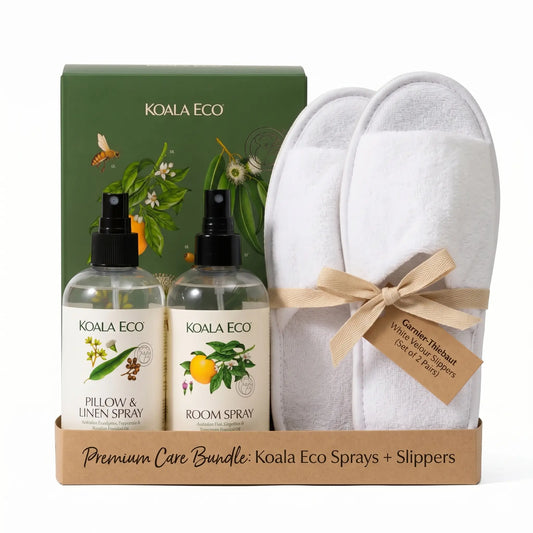 Eco-luxury home care bundle featuring Garnier-Thiebaut white velour slippers and Koala Eco natural aromatherapy sprays (Pillow & Linen spray and Room spray) on studio style. Premium wellness gift set for home experience.