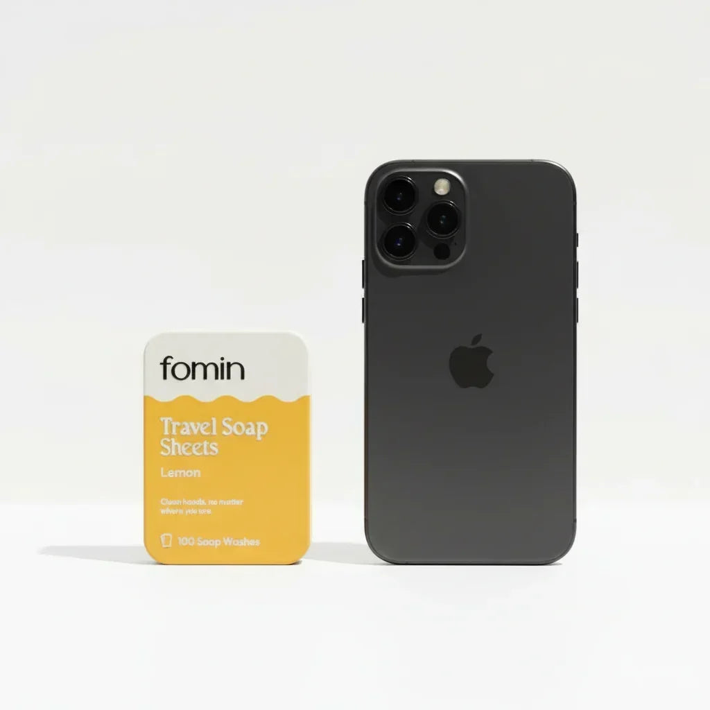 Fomin lemon travel soap sheets package next to a black iPhone for size comparison on white background