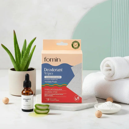 Fomin deodorant wipes variety pack with aloe slices, vitamin E oil, white towels, and aloe plant in spa setting