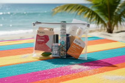 The Refresh Hero Travel Bundle in a clear pouch on a colorful beach towel, featuring Poo-Pourri, soap sheets, and deodorant wipes. Perfect TSA-approved travel essentials for a beach vacation.